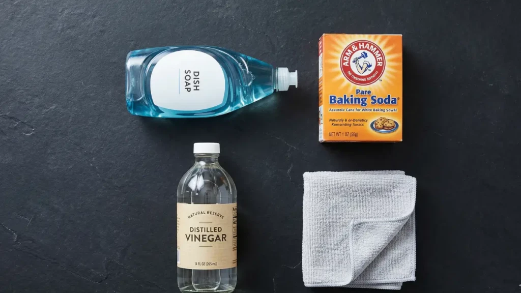  Three common household stain removers: dish soap, baking soda, and white vinegar used for clothing care.