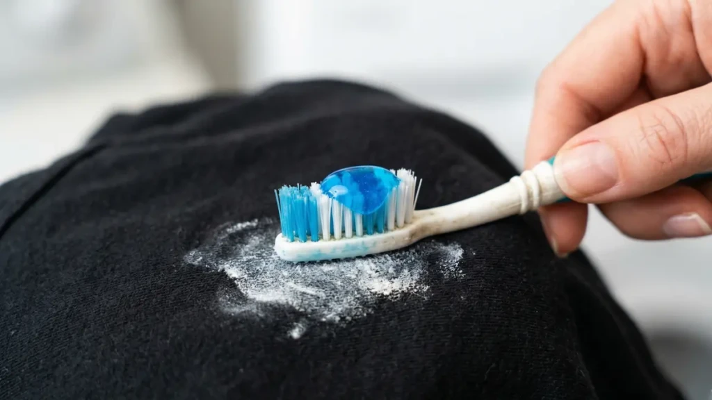 Using a toothbrush and dish soap to quickly remove a deodorant stain from a dark shirt.